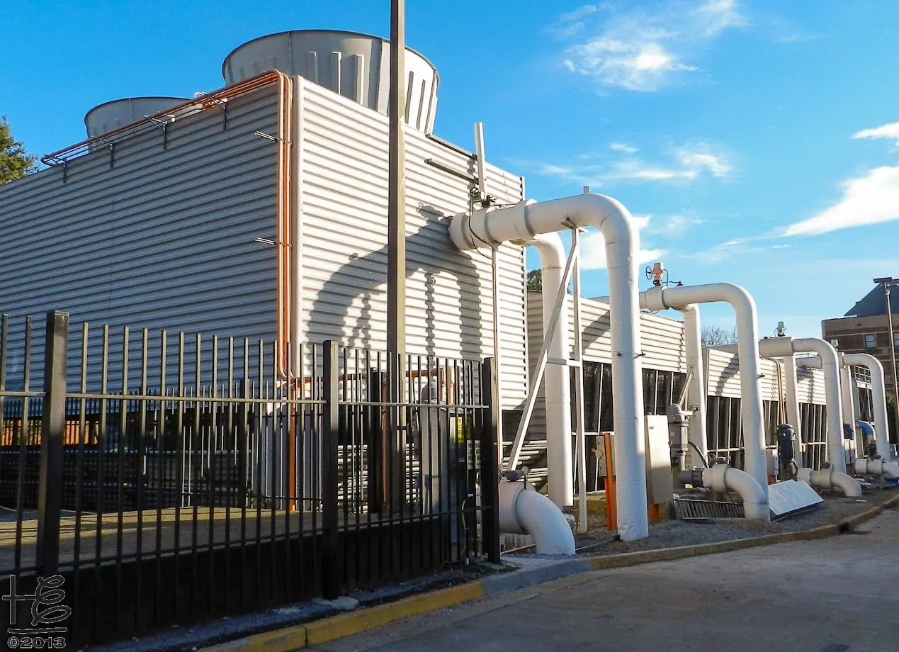 A building with pipes and water tanks on the side.